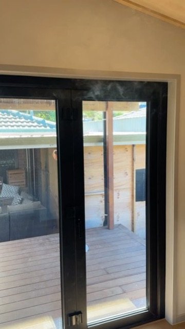Smoke revealing an air leak above a sliding door at Bennett Road